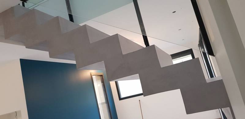 Pose d'un escalier en béton ciré couleur perle dans une maison contemporaine aux Mont d'Or